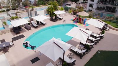 Aerial view of the outdoor pool area with sun loungers & patio umbrellas at Hotel Los Delfines & Casino