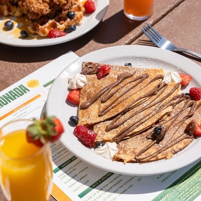 Crepes with chocolate, berries and juice served on a table in Limonada at Showboat Hotel & Resort