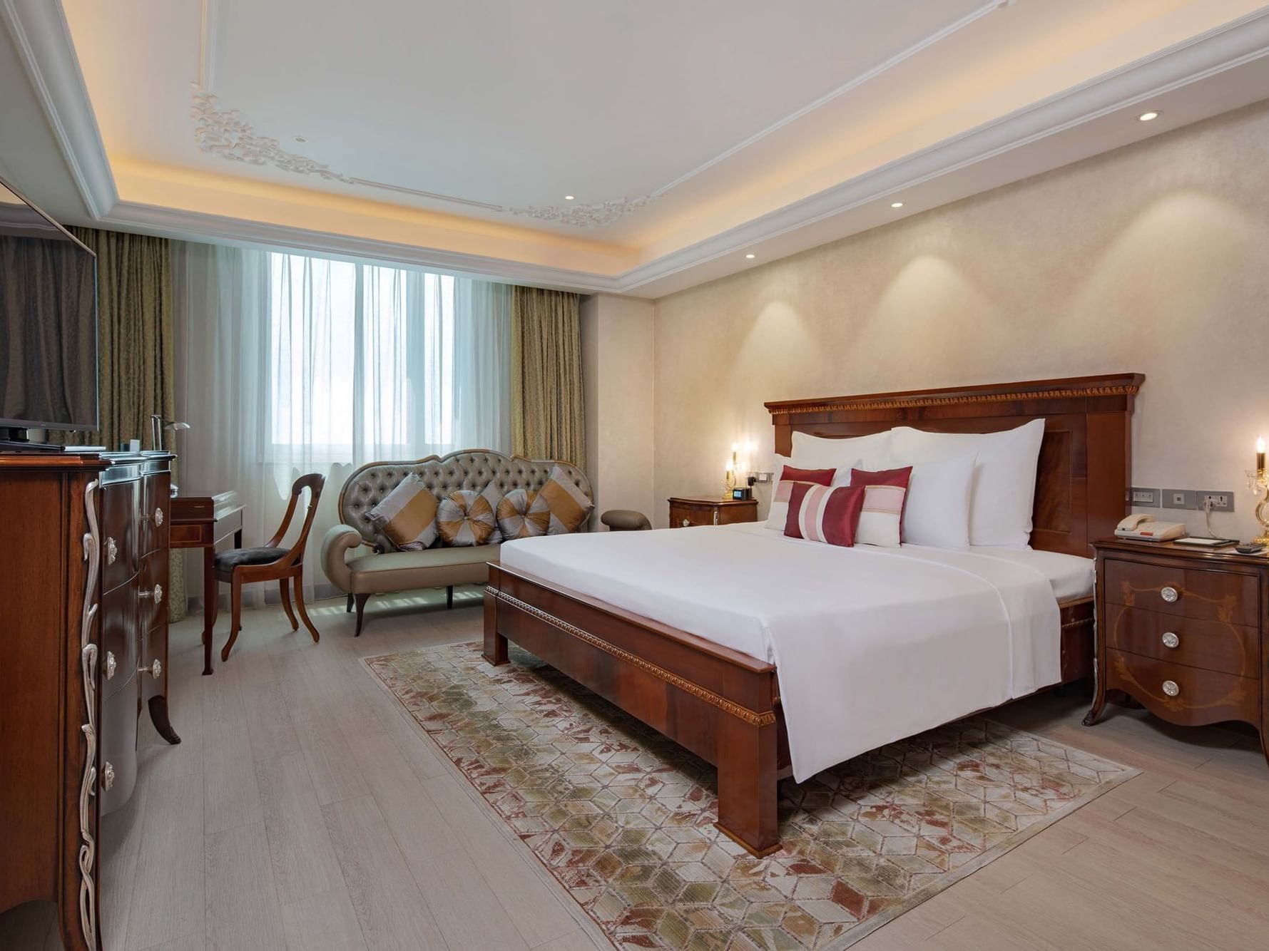 well lit hotel room with king bed and wood furniture