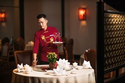 Waiter arranging a table in a restaurant at Hanoi Daewoo Hotel