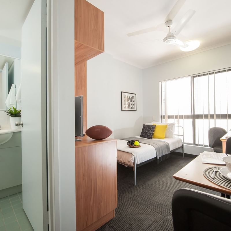Modern studio apartment with single bed, dining area, kitchenette, and bathroom at UniLodge on Margaret