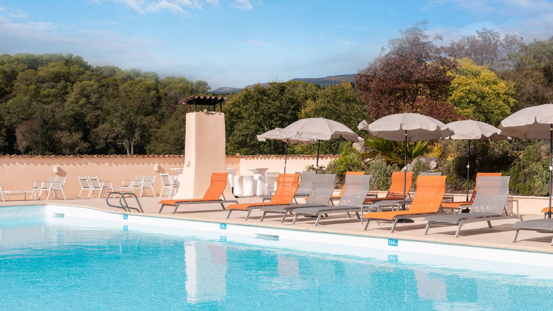 Sunbed area by an outdoor pool at Originals Hotels