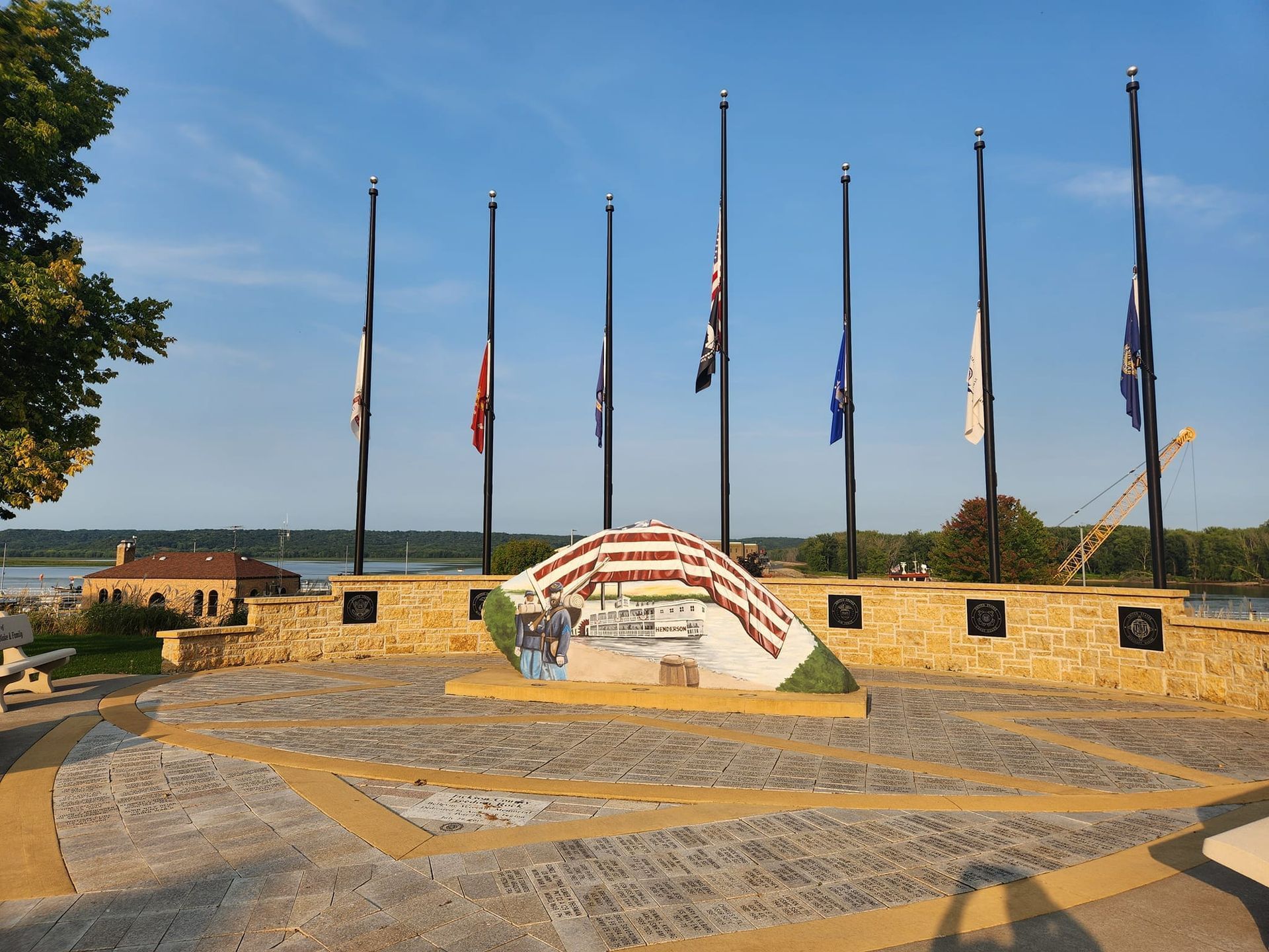 Freedom Rock with multiple flagpoles, an emblematic mural, and scenic river views near Off Shore Resort