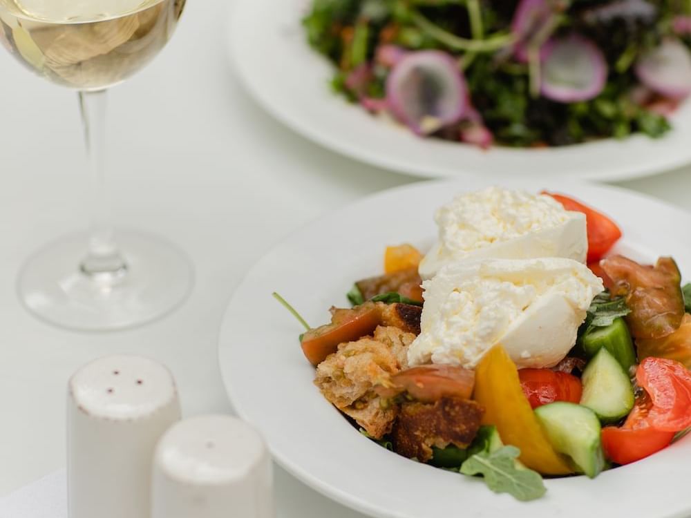 Close-up of veg salad served with cheese in restaurant at Luxe Sunset Boulevard Hotel