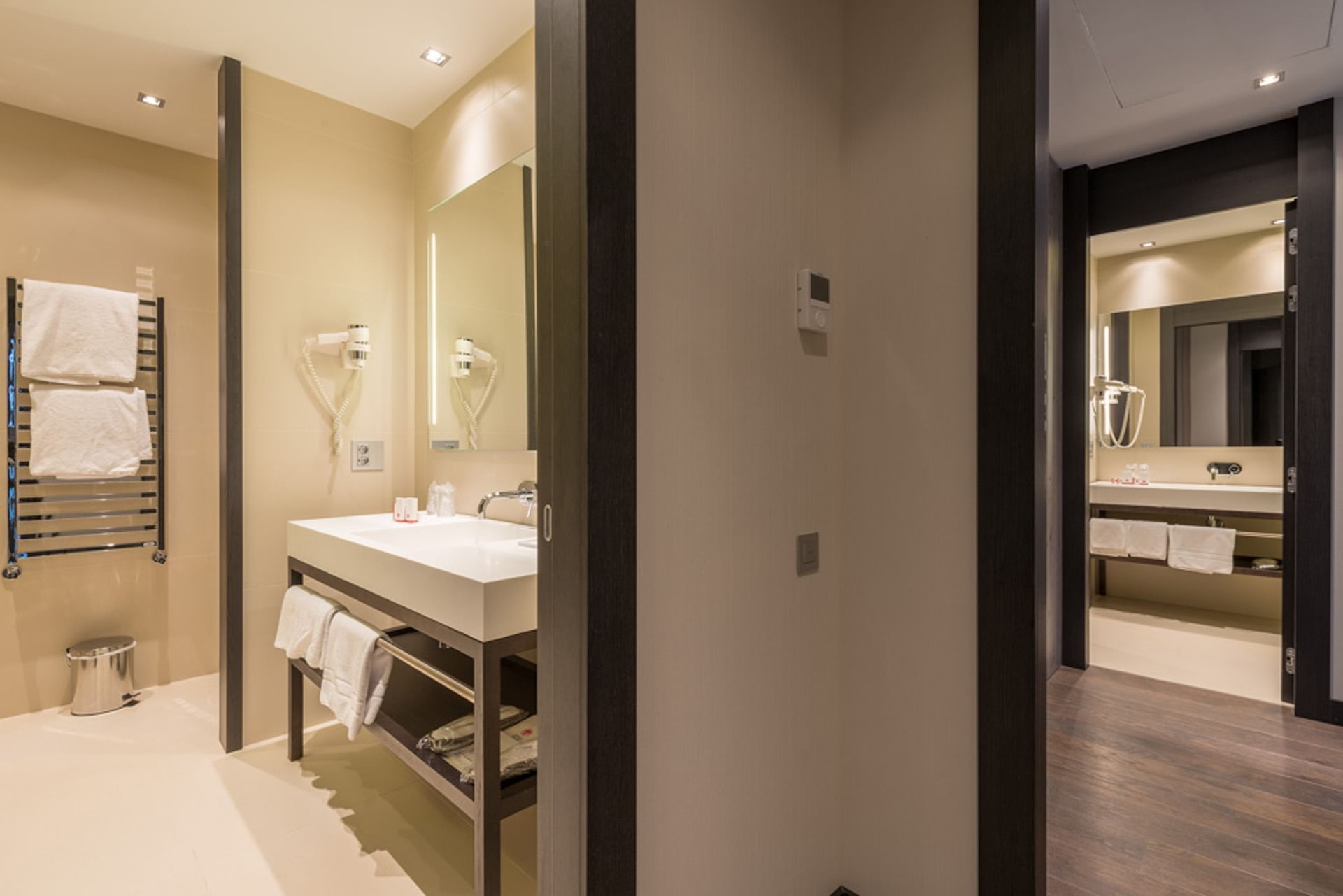 Suite con bagno elegante con doppio lavabo, asciugamani e asciugacapelli a DUPARC Contemporary Suites
