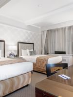 Two beds with a working desk near window in Premier 2 Double Beds at Warwick New York