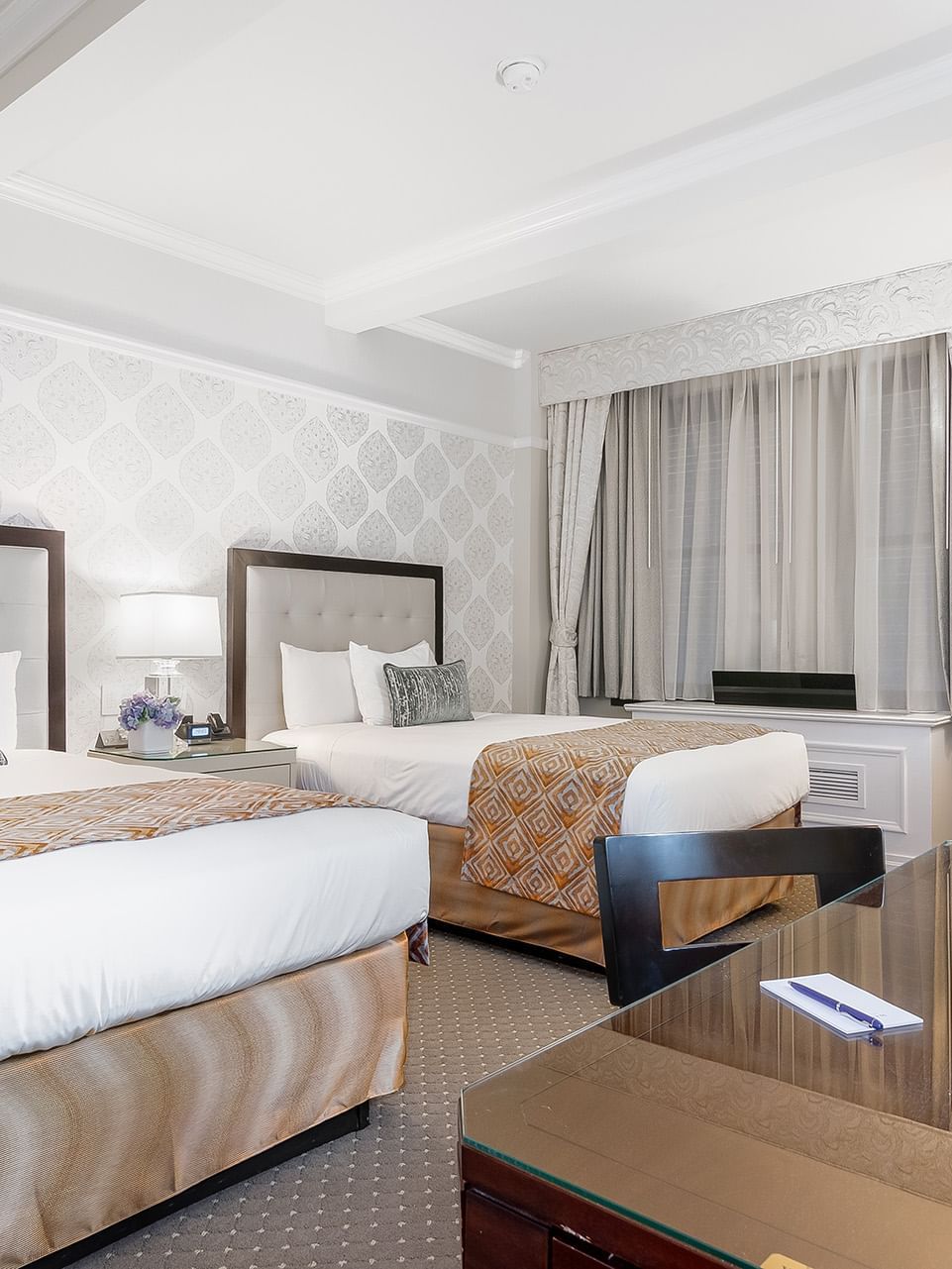 Two beds with a working desk near window in Premier 2 Double Beds at Warwick New York