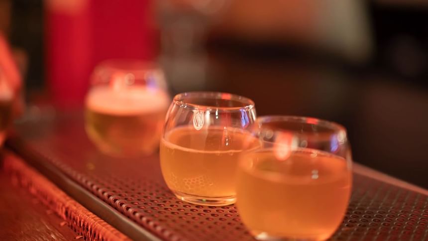 Row of three small craft beer tasting glasses on a metal bar mat in Media Sangre at Araiza Calafia