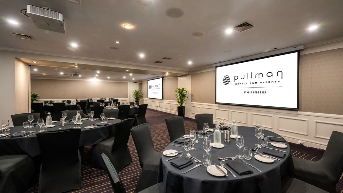 Banquet set-up with projector screens in Cook Room at Pullman Sydney Hyde Park