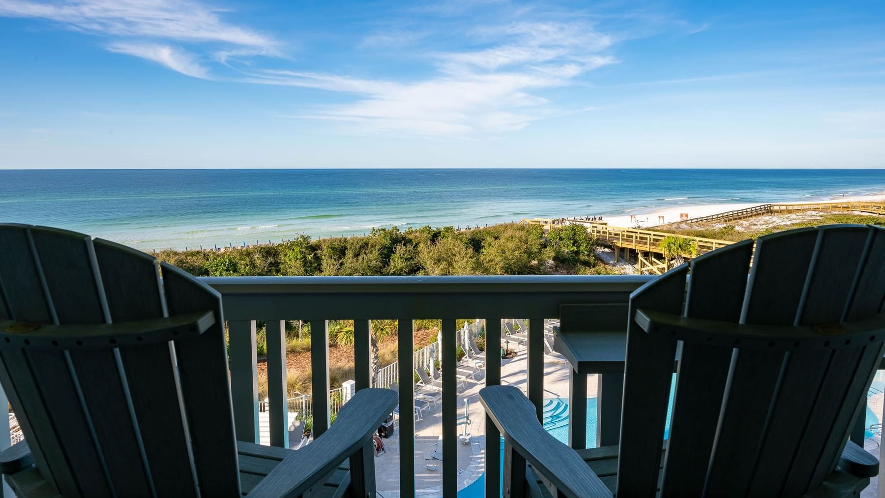 Two Adirondack Chairs overlooking room balcony at WaterColor Inn with view of the Gulf and Pool Area