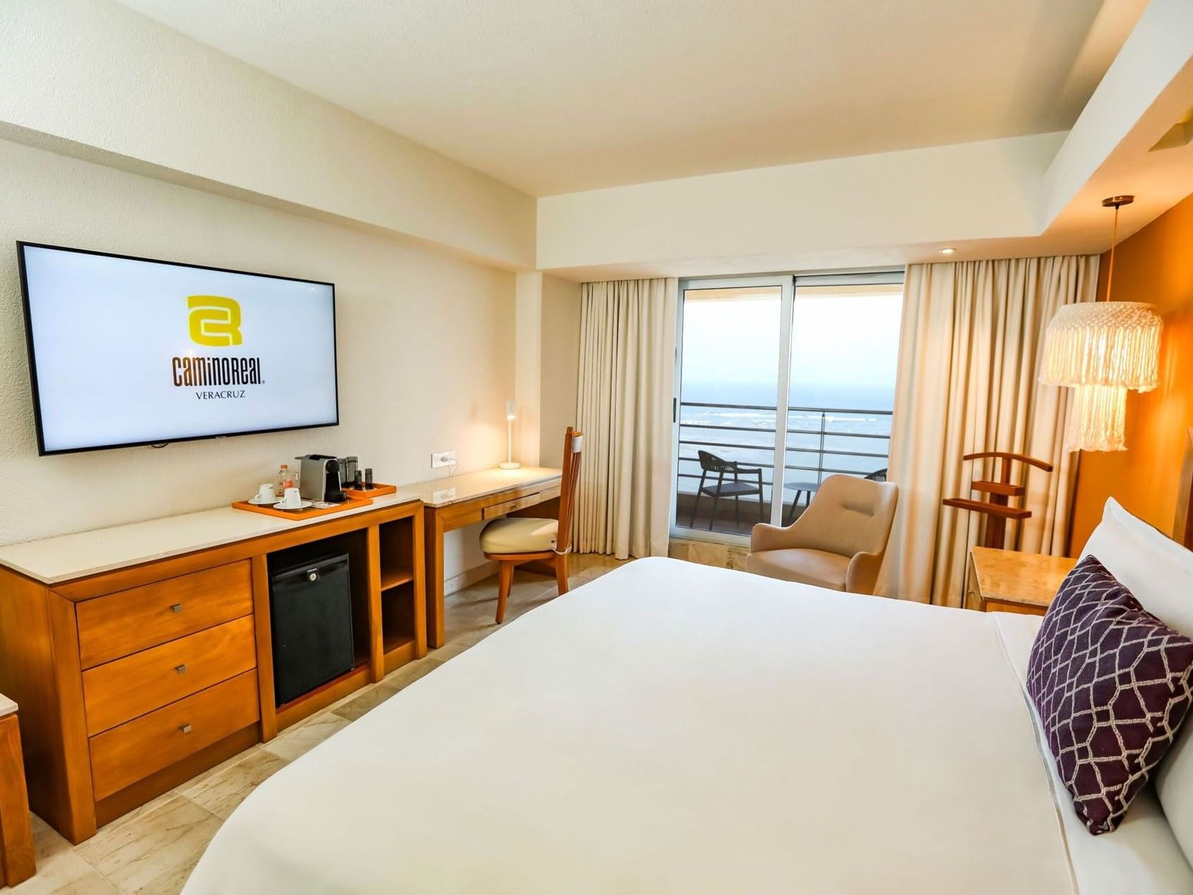 King Camino Real Club with a work desk, television, and large windows facing the waterfront at Camino Real Veracruz
