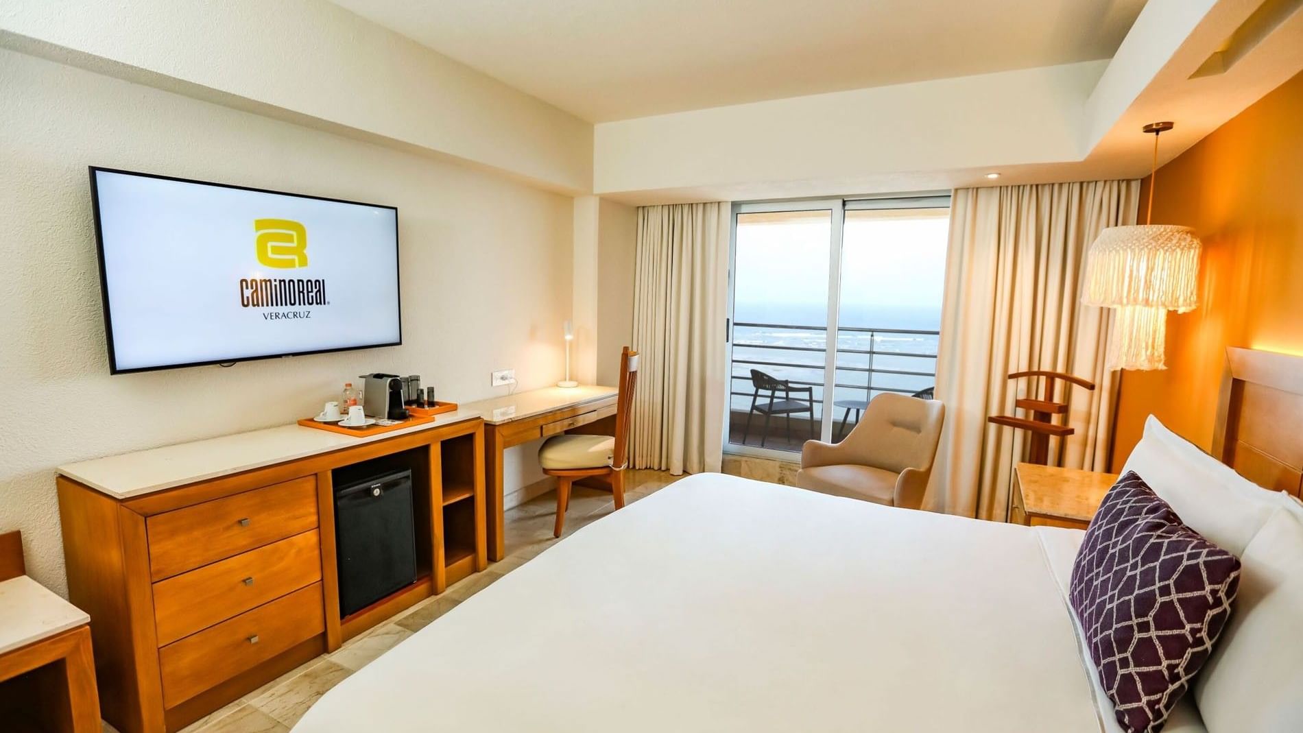 King Camino Real Club with a work desk, television, and large windows facing the waterfront at Camino Real Veracruz