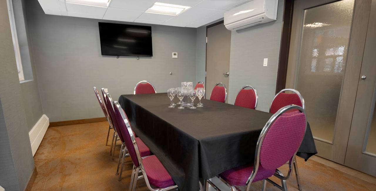 Coast Calgary Downtown Hotel & Suites by APA meeting room with chair, table, air condition, and TV