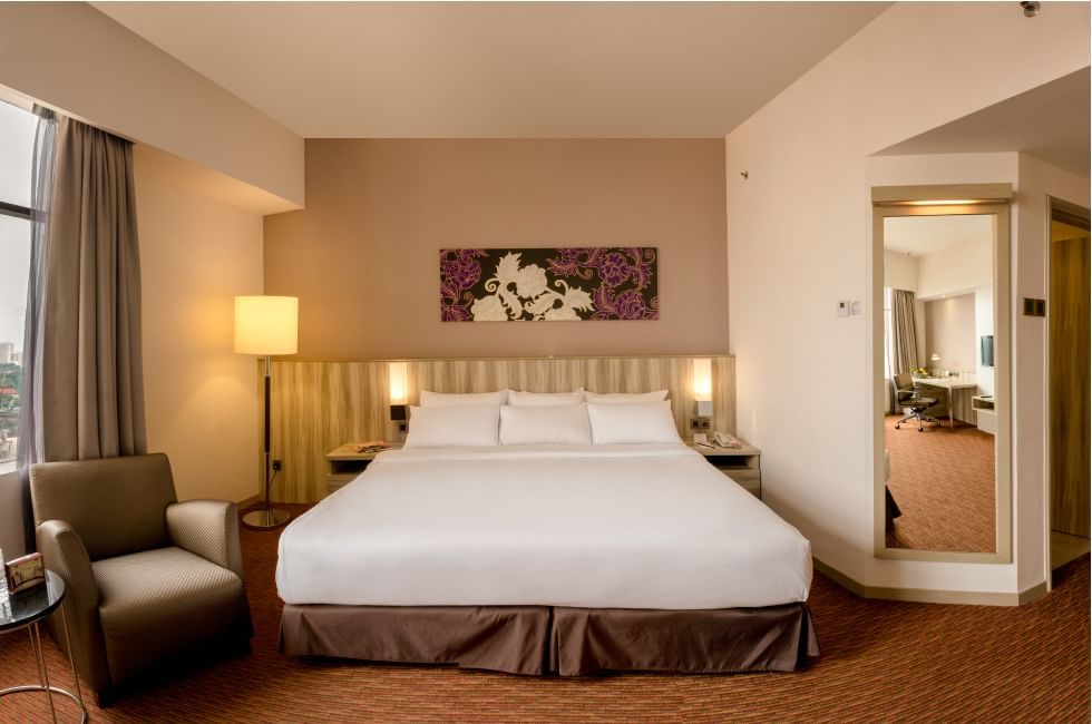 King bed with a single sofa in Deluxe King Room at Sunway Hotel Seberang Jay