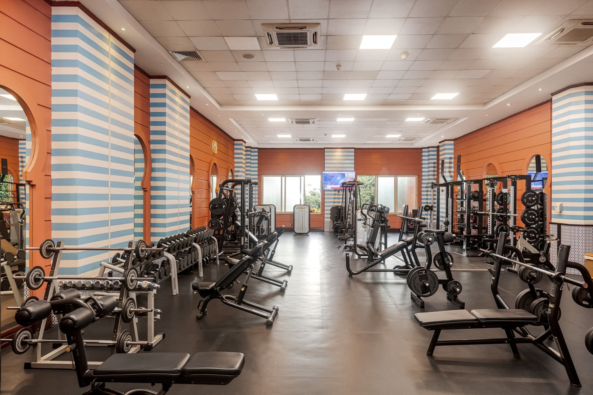 Modern fitness center with weight training equipment and blue-striped walls at Kampala Serena Hotel
