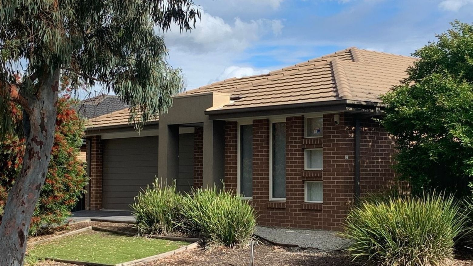 Brick house with brown roof and green garden at La Trobe University Regional Housing.
