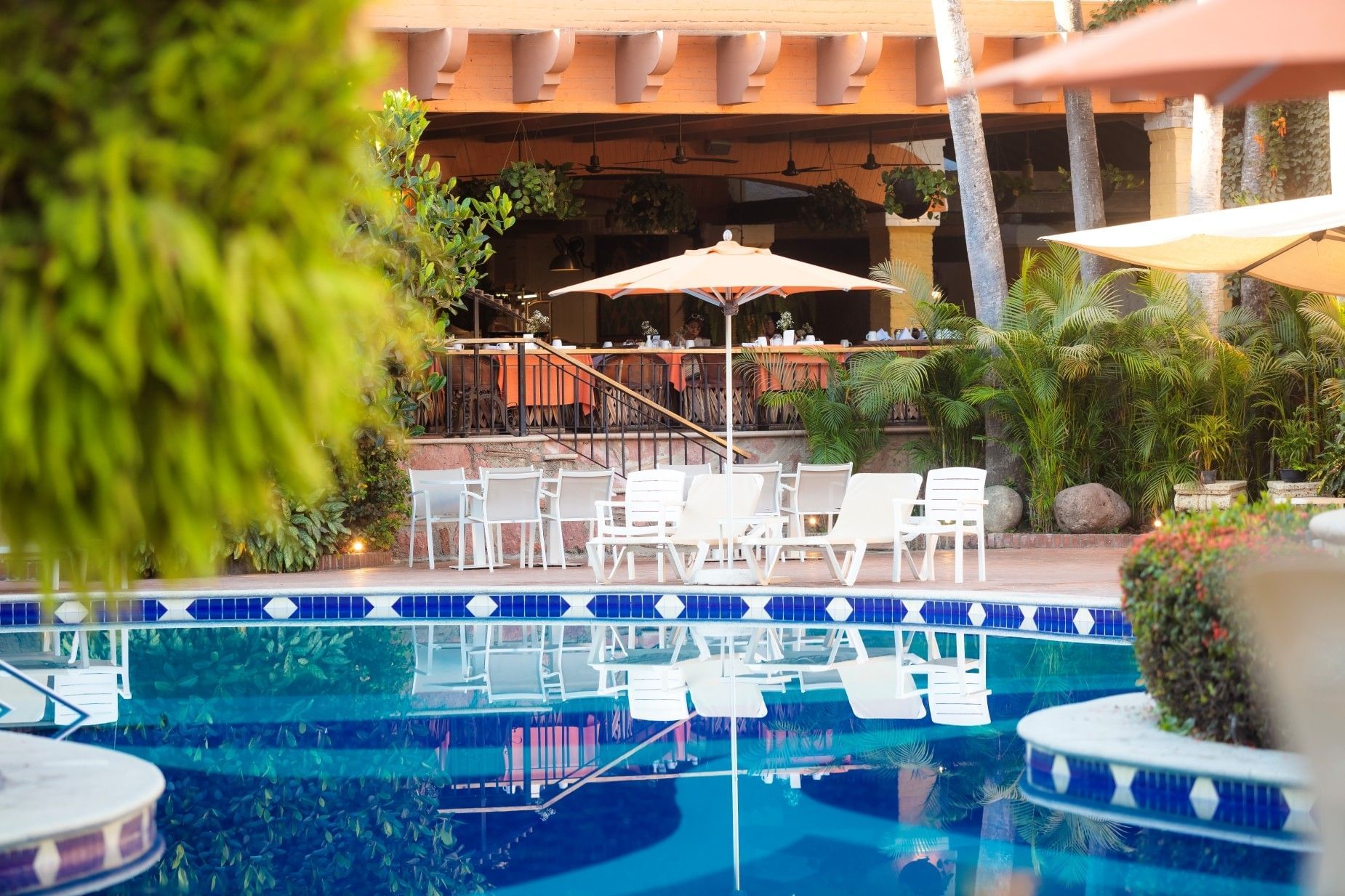 Alberca y área de comedor al aire libre en Hacienda Buenaventura Hotel & Mexican Charm en Puerto Vallarta, mostrando su arquitectura tradicional estilo hacienda mexicana y exuberantes jardines tropicales.