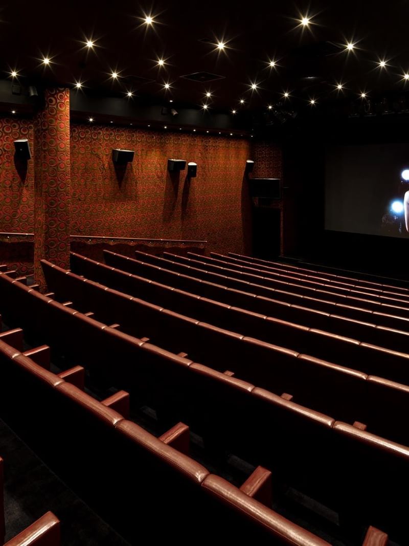 Theatre with empty rows of seating facing a large screen at The May Fair Hotel
