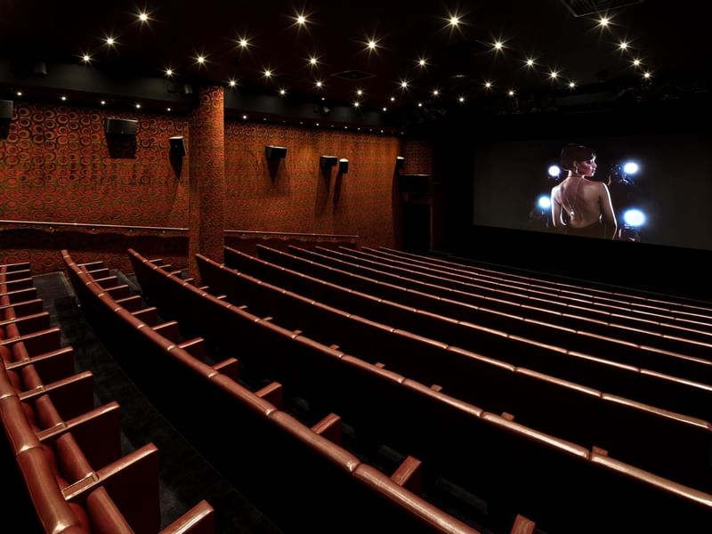 Theatre with empty rows of seating facing a large screen at The May Fair Hotel