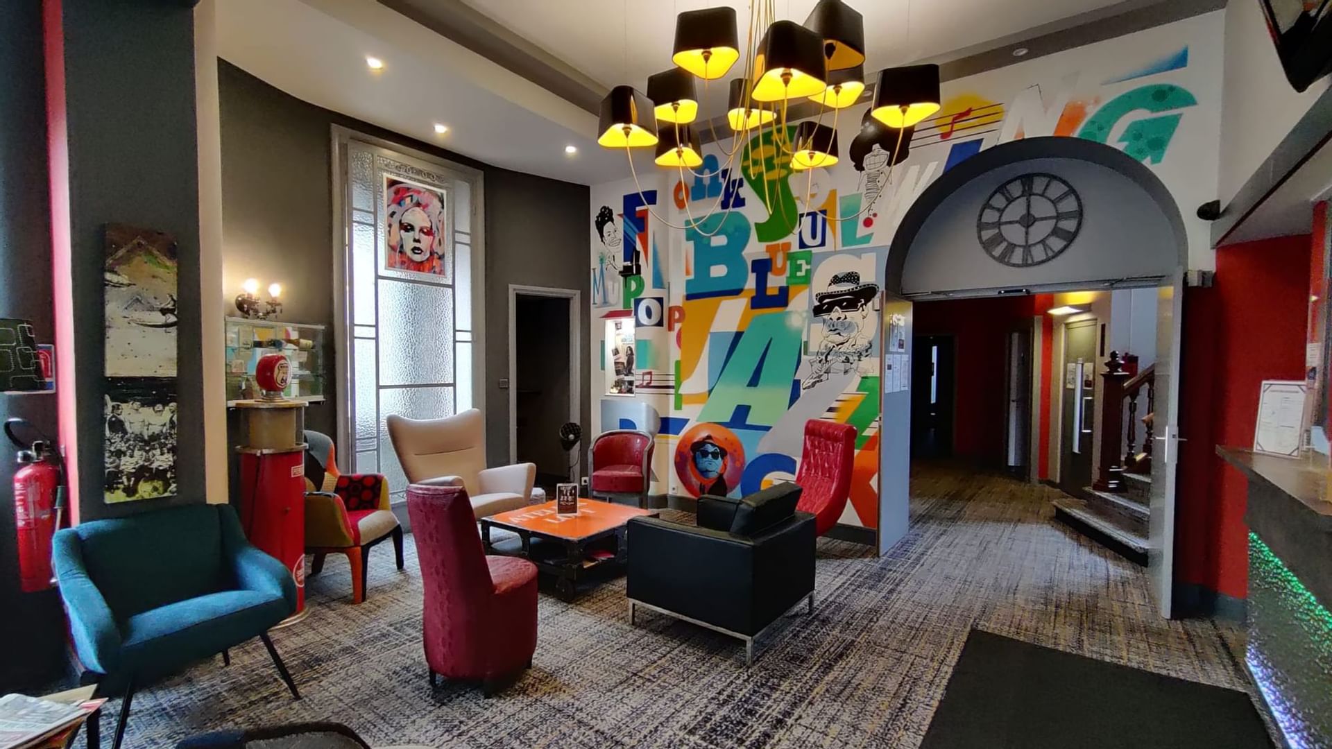 Modern lobby area with mural art at The Originals Hotels