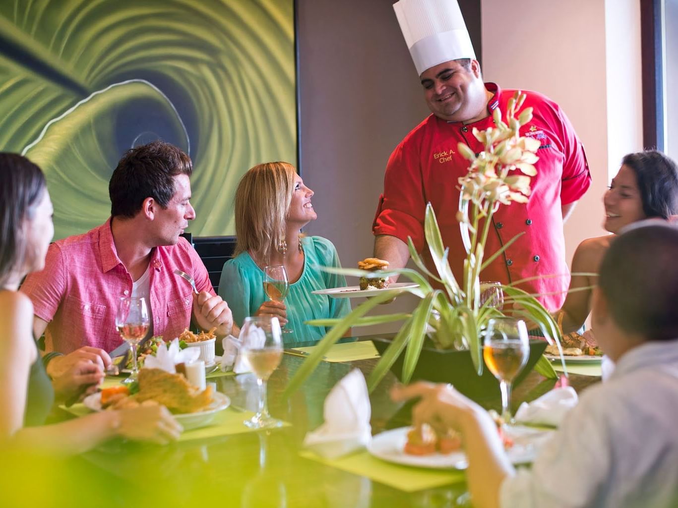 Chef sirviendo comida con una sonrisa en un restaurante de Los Altos Resort