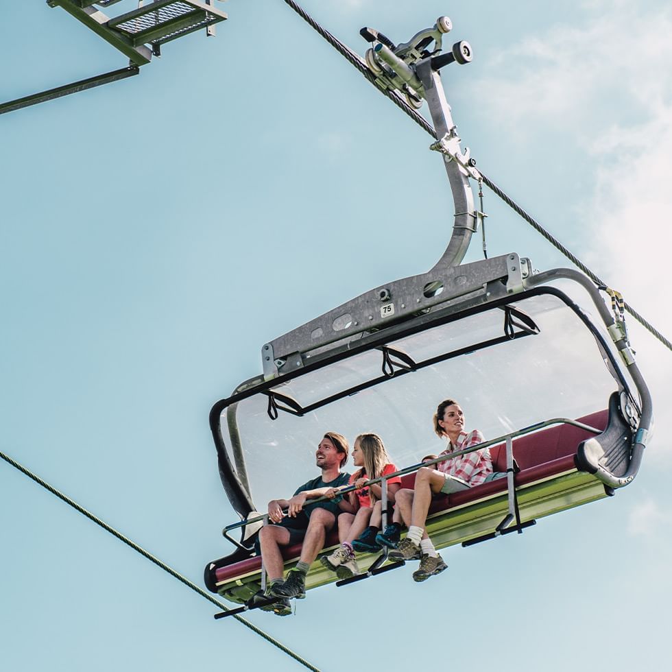 Family enjoying Aineck chair lift ride near Falkensteiner Hotel Cristallo