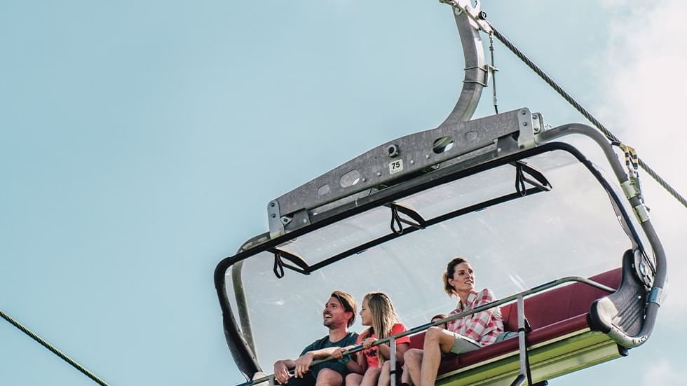 A family enjoying a chairlift ride near Falkensteiner Hotels