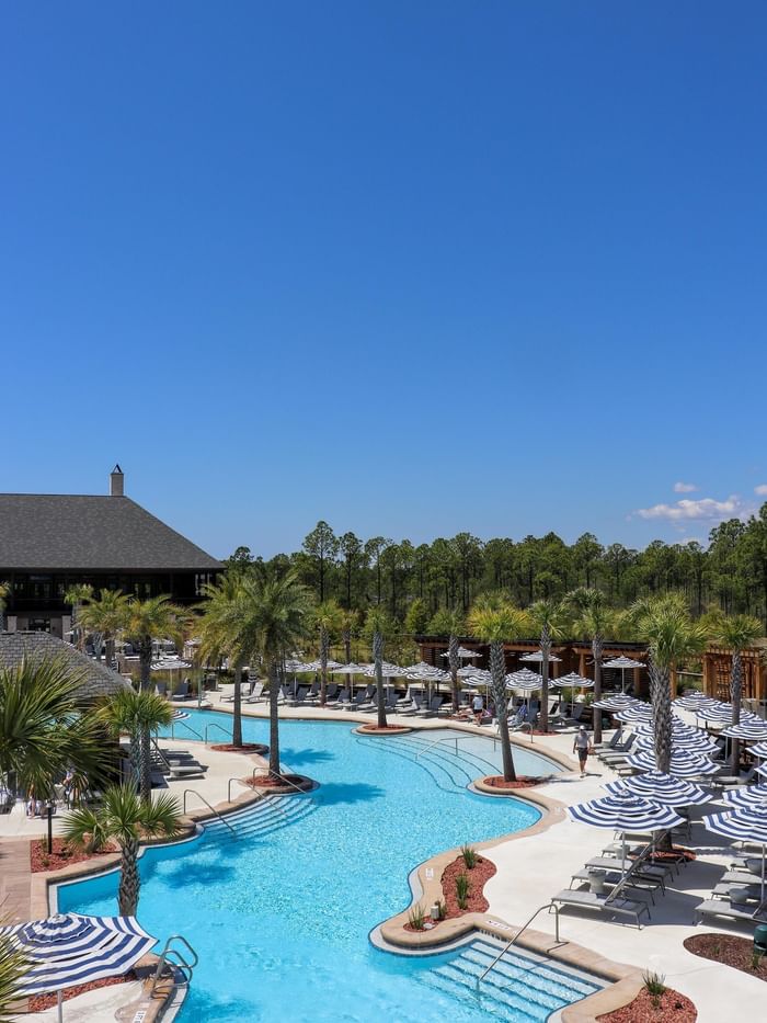 Camp Creek resort pool area with umbrellas and palm trees near Watersound Inn, Inlet Beach.