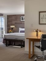 Office desk with a black chair by a gold lamp under framed in Executive Suite at Warwick Denver