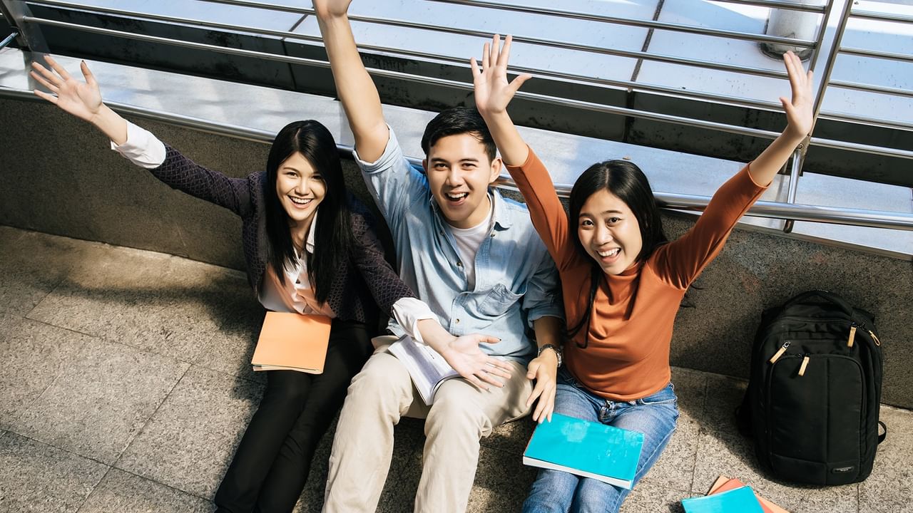 university students sitting together with notebooks and backpacks