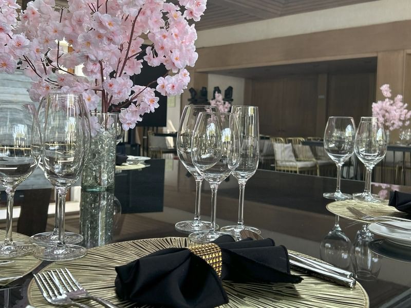 Elegantly set table with wine glasses and floral centerpiece in Salón y Foyer Kioto at Grand Fiesta Americana Sumiya Cuernavaca.