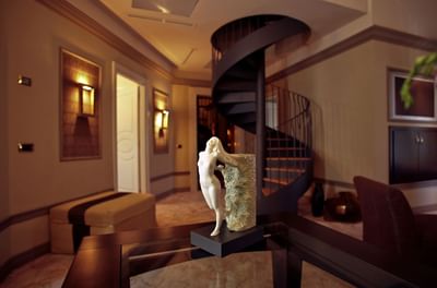 Spiral staircase & statue in the living area in Presidential suite at Grand Visconti Palace