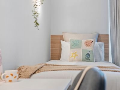 Cozy bedroom with marine-themed pillows and a decorative wall at UniLodge Brisbane City.