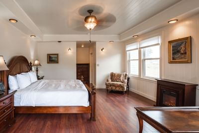 Cozy bed and sofa chair with hearth in Carriage House at Banning House Lodge