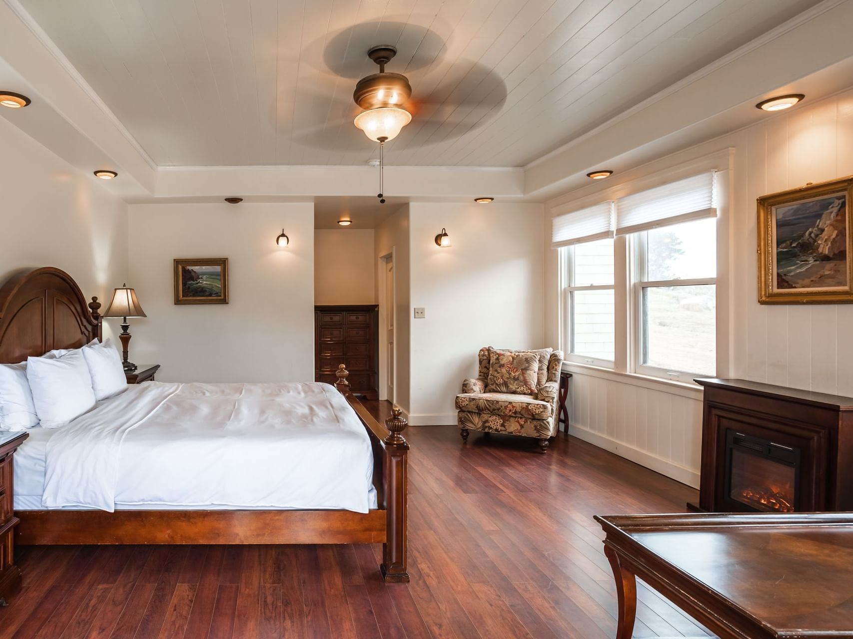 Fireplace by cozy bed in Carriage House Room with Jacuzzi Tub at Banning House Lodge