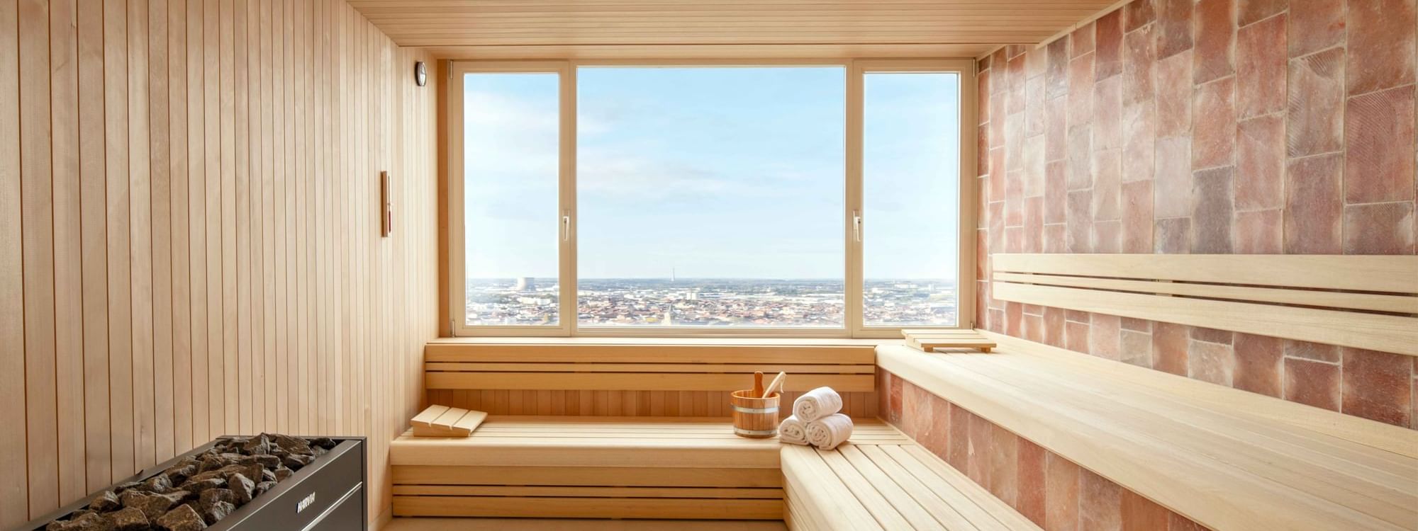 Salle de sauna avec grande fenêtre donnant sur un paysage urbain de la ville de Bruxelles