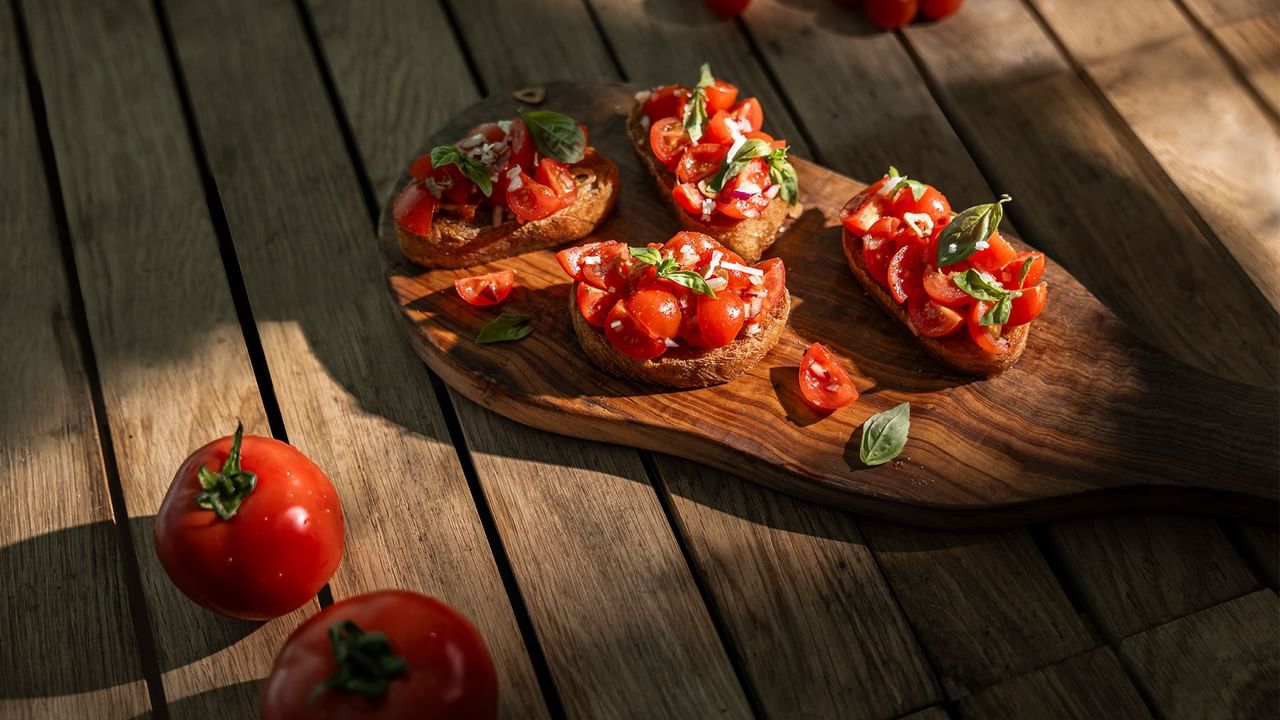 Baguette mit Tomaten und Basilikum auf Holzbrett