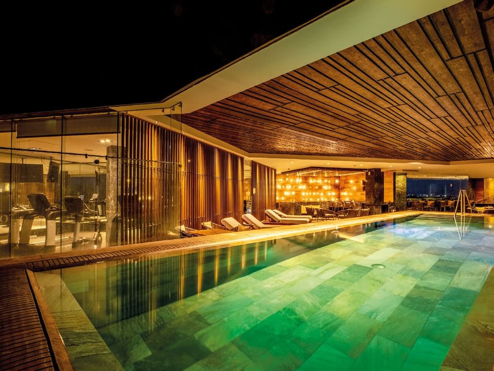 Piscina cubierta con luces nocturnas en FA Hotels & Resorts