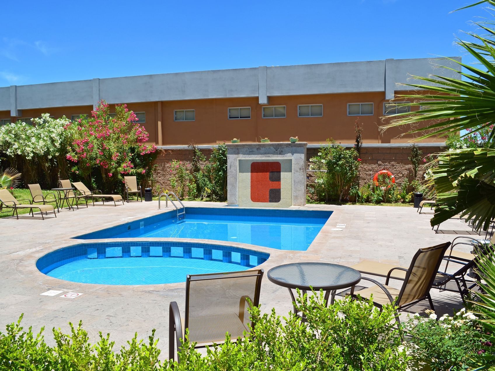 Outdoor swimming pool with pool chairs at Fiesta Inn Hotels