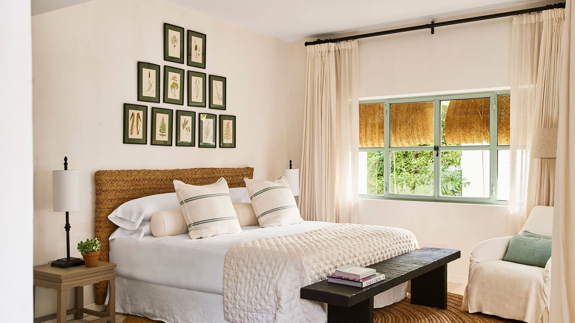 Three-bedroom villa featuring a woven headboard and a dark wooden bench placed on a round rug at Marbella Club