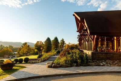 Exterior view of the Lake Placid Club Grandview lodge with stone steps leading up to the large timber and glass entrance