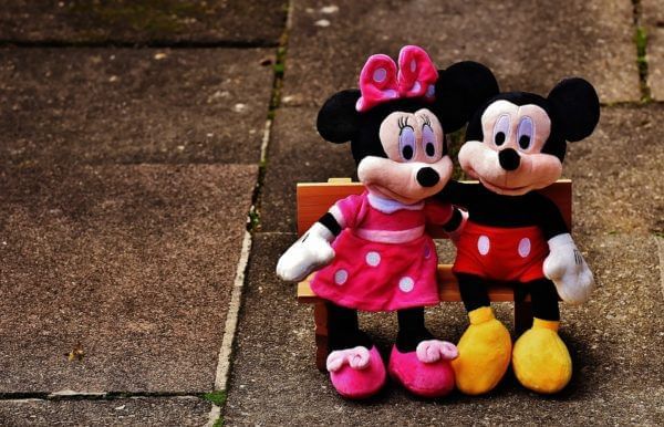 Plush toys of Minnie and Mickey Mouse sitting on a bench together at Lake Buena Vista Resort Village & Spa