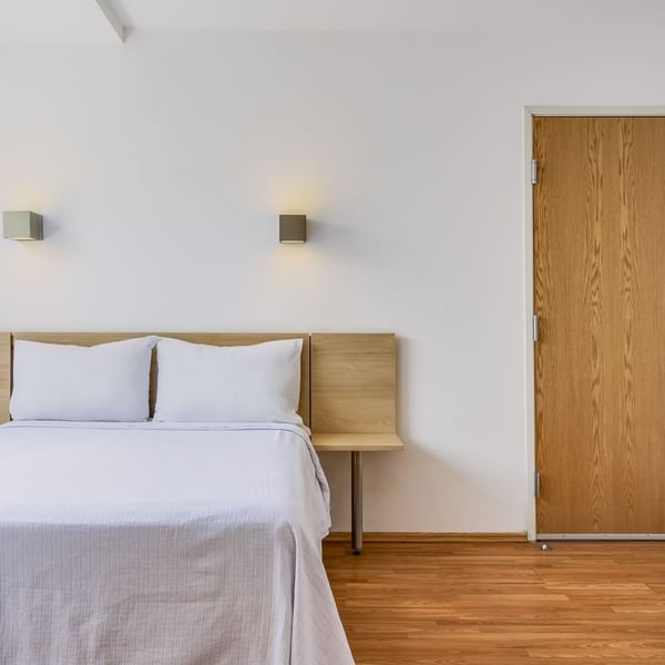 Bed with wall lamps in Superior Room 1 Queen at One Hotels