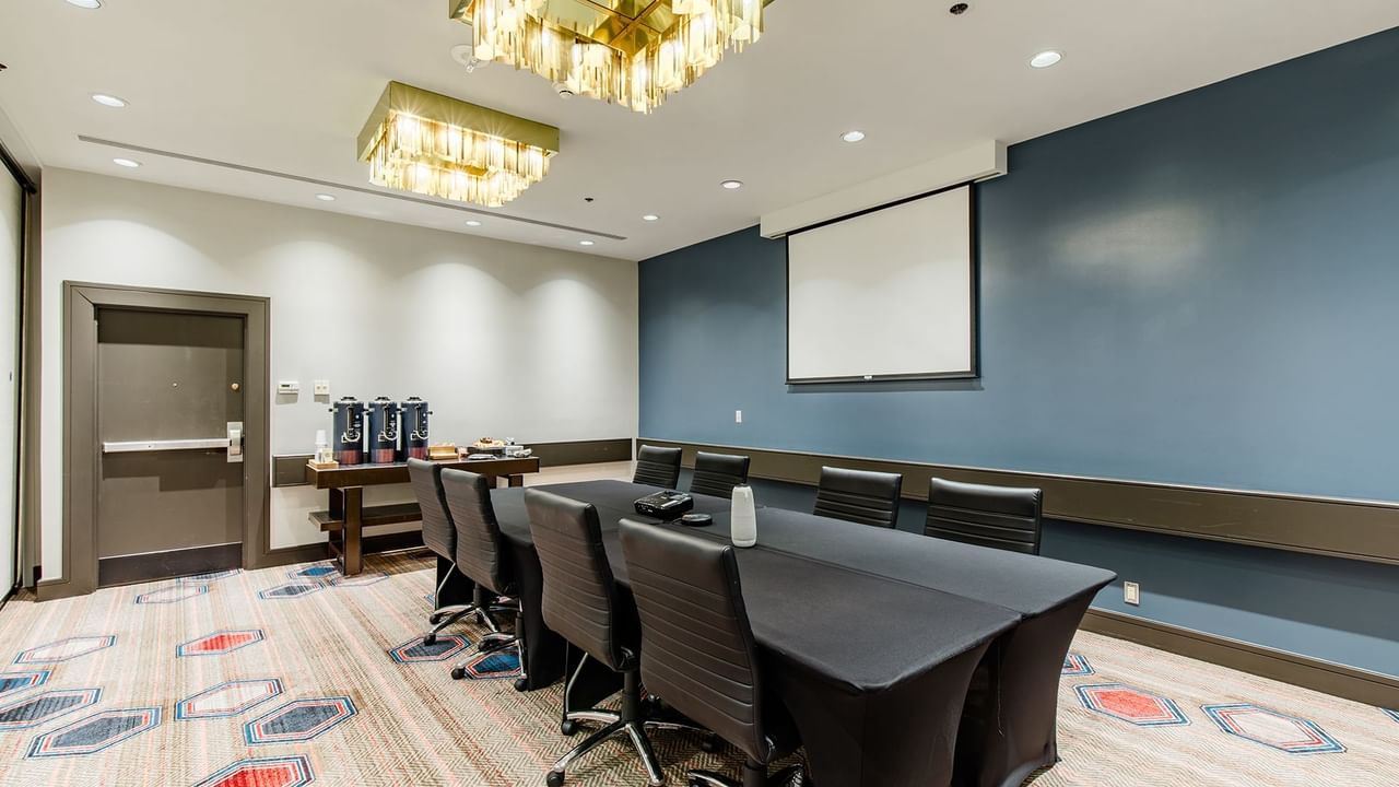 Meeting room with chairs, tables, and projection screen