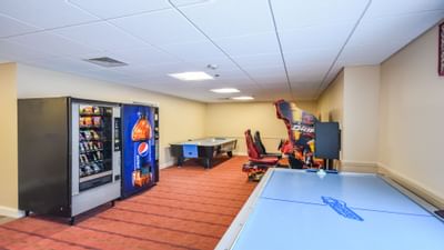 Fox Ridge Resort game room with two pool tables, two vending machines, and an arcade game on a red carpet.