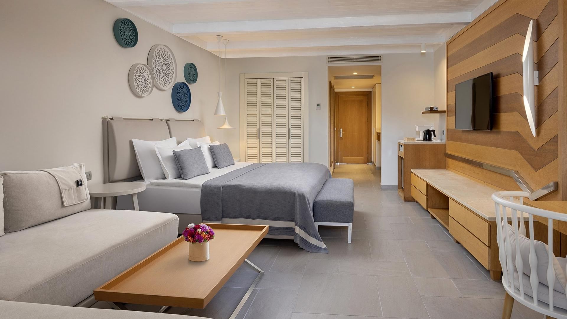 Titanic Luxury Collection Bodrum's Superior Sea View Room with bed, couch, coffee table, TV, and chair.