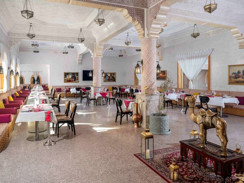 Elegant Turkish restaurant interior with ornate columns, traditional lanterns, and white-clothed tables at Pickalbatros Alf Leila.