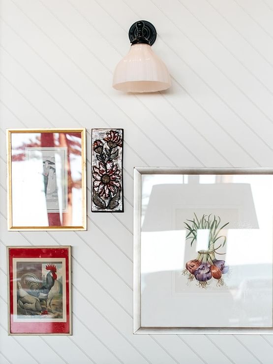  Bistro Manly at Elysium Manly with colorful framed art pieces by a white paneled wall under a simple sconce