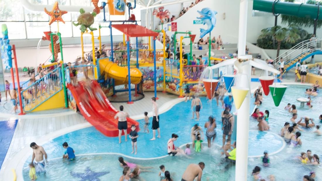Interior of the Sydney Aquatic Centre, crowded with kids & water activities near Pullman Sydney Olympic Park 
