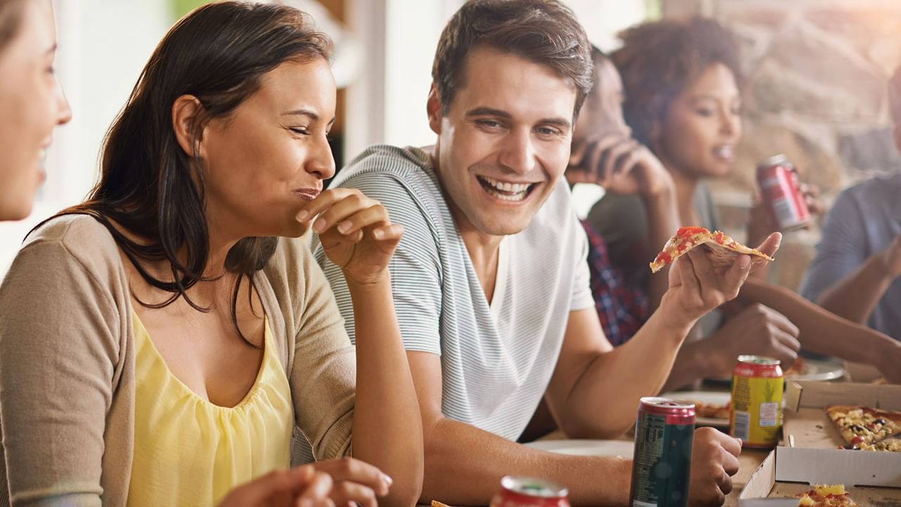 girl laughing while eating with friends